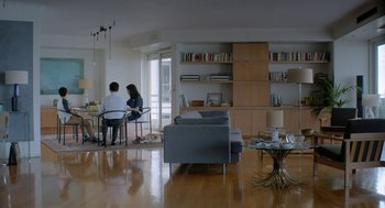 Movie still from “Pity” (2018), directed by Babis Makridis – Two people are sitting in a living room; Wide shot, High angle