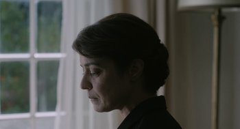 Movie still from “Pity” (2018), directed by Babis Makridis – A person looking to the side; Close Up shot, Over the shoulder angle