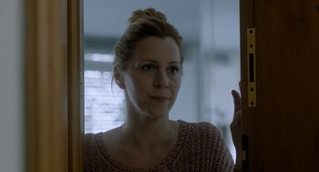 Movie still from “Pity” (2018), directed by Babis Makridis – A person looking at the camera; Close Up shot, Over the shoulder angle