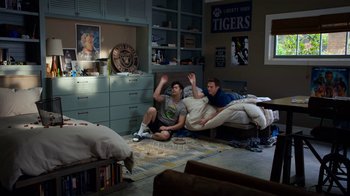 Movie still from “13 Reasons Why” (2017), created by Brian Yorkey – Two young men sitting on the floor of a living room; Wide shot, High angle