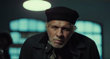 Movie still from “Pixote” (1980), directed by Hector Babenco – An older man wearing a black hat and jacket; Close Up shot, Low angle