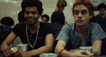 Movie still from “Pixote” (1980), directed by Hector Babenco – Two young men sitting at a table drinking coffee; Medium shot, Over the shoulder angle