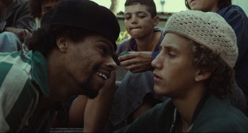 Movie still from “Pixote” (1980), directed by Hector Babenco – A group of young men sitting next to each other; Close Up shot, Over the shoulder angle