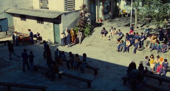 Movie still from “Pixote” (1980), directed by Hector Babenco – A group of people sitting and standing around a building; Extreme Wide shot, High angle