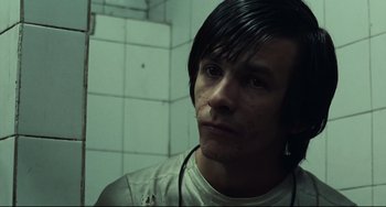 Movie still from “Pixote” (1980), directed by Hector Babenco – A man with long black hair looking at the camera; Close Up shot, High angle