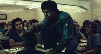 Movie still from “Pixote” (1980), directed by Hector Babenco – A man is pointing at something in a room; Medium shot, Over the shoulder angle