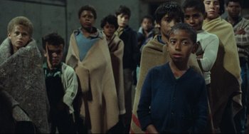 Movie still from “Pixote” (1980), directed by Hector Babenco – A group of young boys standing next to each other; Medium shot, High angle