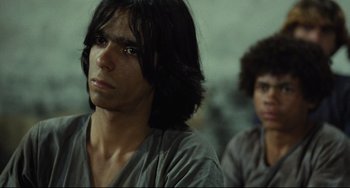 Movie still from “Pixote” (1980), directed by Hector Babenco – Two young men sitting next to each other in a room; Close Up shot, Over the shoulder angle