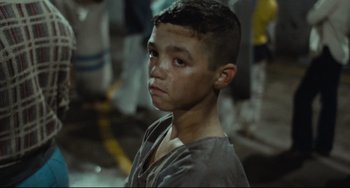 Movie still from “Pixote” (1980), directed by Hector Babenco – A young boy with a shaved head is looking into the camera; Close Up shot, High angle