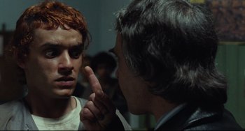 Movie still from “Pixote” (1980), directed by Hector Babenco – A man with red hair is pointing at another man's face; Close Up shot, Over the shoulder angle