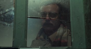 Movie still from “Pixote” (1980), directed by Hector Babenco – A man wearing a scarf looking out of a window; Close Up shot, Low angle