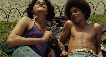 Movie still from “Pixote” (1980), directed by Hector Babenco – Two young men laying on the ground with one holding a flower; Medium shot, Low angle