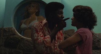 Movie still from “Pixote” (1980), directed by Hector Babenco – A man and a woman are standing in front of a painting; Medium shot, Over the shoulder angle