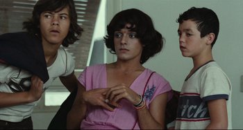 Movie still from “Pixote” (1980), directed by Hector Babenco – A group of young people sitting next to each other; Medium shot, Over the shoulder angle