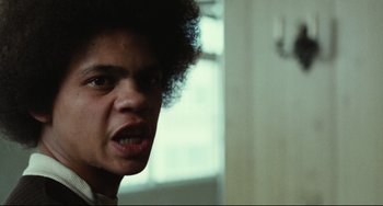 Movie still from “Pixote” (1980), directed by Hector Babenco – A person with a curly hair; Close Up shot, Low angle