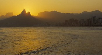Movie still from “Pixote” (1980), directed by Hector Babenco – The sun is setting over a large body of water; Extreme Wide shot, Low angle