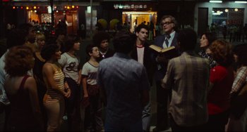Movie still from “Pixote” (1980), directed by Hector Babenco – A group of people standing on a sidewalk; Wide shot, Over the shoulder angle