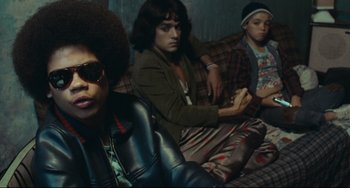 Movie still from “Pixote” (1980), directed by Hector Babenco – A group of people sitting on a couch in a living room; Medium shot, Low angle