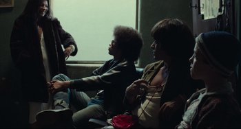 Movie still from “Pixote” (1980), directed by Hector Babenco – A group of people sitting on a couch; Medium shot, Over the shoulder angle