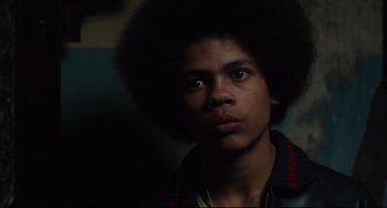 Movie still from “Pixote” (1980), directed by Hector Babenco – A young man with an afro is looking at the camera; Close Up shot, Low angle
