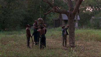 Movie still from “Places in the Heart” (1984), directed by Robert Benton – A group of people standing next to a tree in a field; Extreme Wide shot, Low angle