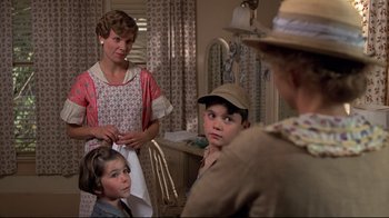 Movie still from “Places in the Heart” (1984), directed by Robert Benton – A group of people sitting in a living room; Medium shot, Over the shoulder angle