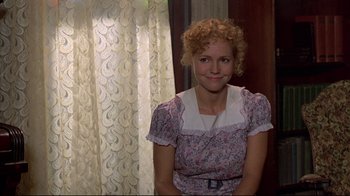 Movie still from “Places in the Heart” (1984), directed by Robert Benton – A woman with curly red hair sitting in front of a window; Medium shot, Over the shoulder angle