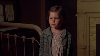 Movie still from “Places in the Heart” (1984), directed by Robert Benton – A little girl standing next to a bed in a dark room; Close Up shot, High angle