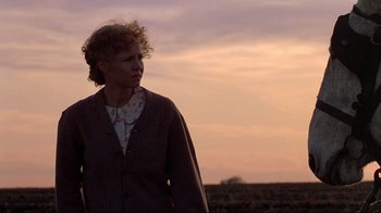Movie still from “Places in the Heart” (1984), directed by Robert Benton – A woman standing in the middle of an open field at sunset; Medium shot, Low angle