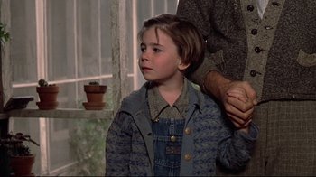 Movie still from “Places in the Heart” (1984), directed by Robert Benton – A young boy standing next to an older man; Close Up shot, Over the shoulder angle