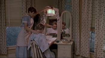 Movie still from “Places in the Heart” (1984), directed by Robert Benton – A woman cutting a man's hair in front of a mirror; Medium shot, High angle