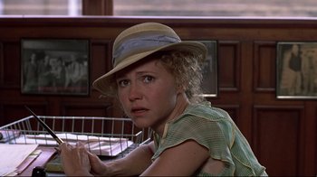 Movie still from “Places in the Heart” (1984), directed by Robert Benton – A woman with a hat sitting in front of a cage; Close Up shot, Over the shoulder angle