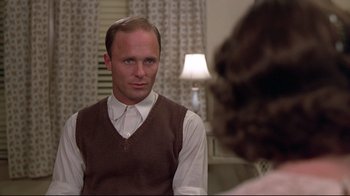Movie still from “Places in the Heart” (1984), directed by Robert Benton – A man wearing a brown vest looking into a mirror; Close Up shot, Over the shoulder angle