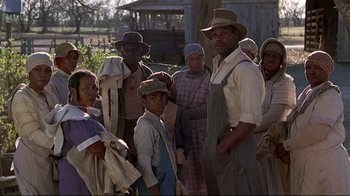Movie still from “Places in the Heart” (1984), directed by Robert Benton – A group of people standing next to each other in a field; Medium shot, Over the shoulder angle