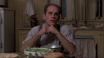 Movie still from “Places in the Heart” (1984), directed by Robert Benton – A man sitting in front of a bowl of green beans; Close Up shot, Low angle
