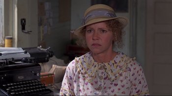 Movie still from “Places in the Heart” (1984), directed by Robert Benton – A woman in a hat and a dress looking at the camera; Close Up shot, Over the shoulder angle