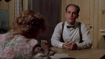 Movie still from “Places in the Heart” (1984), directed by Robert Benton – A man sitting at a wooden table with a woman; Medium shot, Over the shoulder angle