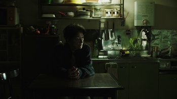 A person sitting at a table in a kitchen