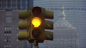 Movie still from “Planes, Trains & Automobiles” (1987), directed by John Hughes – A traffic light sitting in the middle of a street; Extreme Close Up shot, Low angle