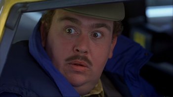 Movie still from “Planes, Trains & Automobiles” (1987), directed by John Hughes – A person wearing a hat and a jacket; Close Up shot, Over the shoulder angle