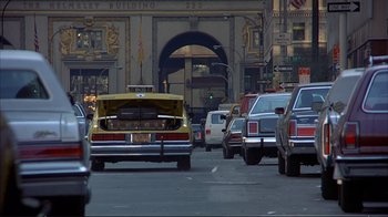 Movie still from “Planes, Trains & Automobiles” (1987), directed by John Hughes – A bunch of cars that are on the street; Wide shot, Low angle