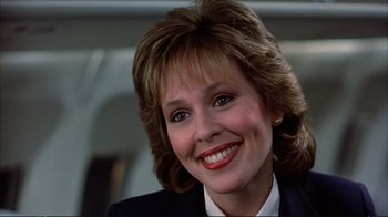 Movie still from “Planes, Trains & Automobiles” (1987), directed by John Hughes – A person wearing a suit and smiling; Close Up shot, Low angle