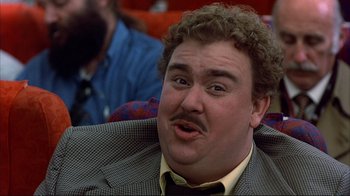 Movie still from “Planes, Trains & Automobiles” (1987), directed by John Hughes – A person wearing a suit and tie; Close Up shot, Low angle