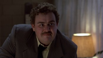 Movie still from “Planes, Trains & Automobiles” (1987), directed by John Hughes – A person wearing a suit and tie; Close Up shot, Over the shoulder angle