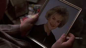 Movie still from “Planes, Trains & Automobiles” (1987), directed by John Hughes – A person holding a picture of a woman in front of a mirror; Extreme Close Up shot, Over the shoulder angle