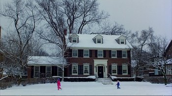 Movie still from “Planes, Trains & Automobiles” (1987), directed by John Hughes – Two children playing in the snow outside of a house; Extreme Wide shot, Low angle