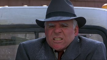 Movie still from “Planes, Trains & Automobiles” (1987), directed by John Hughes – An older man wearing a hat and a suit; Close Up shot, Low angle