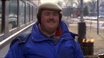 Movie still from “Planes, Trains & Automobiles” (1987), directed by John Hughes – A man in a hat and a blue jacket; Close Up shot, Over the shoulder angle