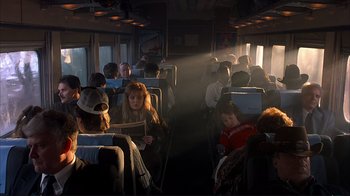 Movie still from “Planes, Trains & Automobiles” (1987), directed by John Hughes – A group of people sitting on a train; Wide shot, High angle