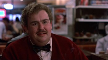 Movie still from “Planes, Trains & Automobiles” (1987), directed by John Hughes – A person with a mustache wearing a bow tie; Close Up shot, Over the shoulder angle